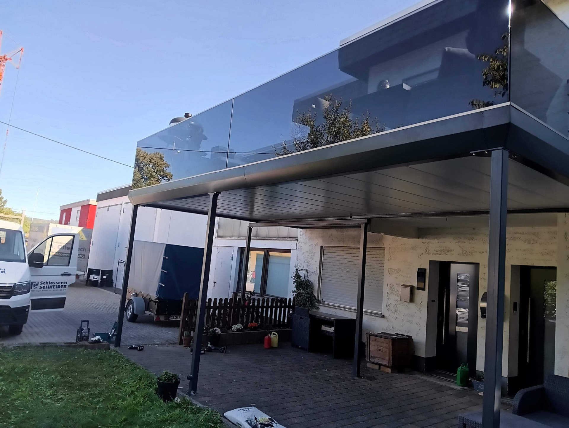 Terrassenüberdachung aus Stahl mit Glasgeländer darüber