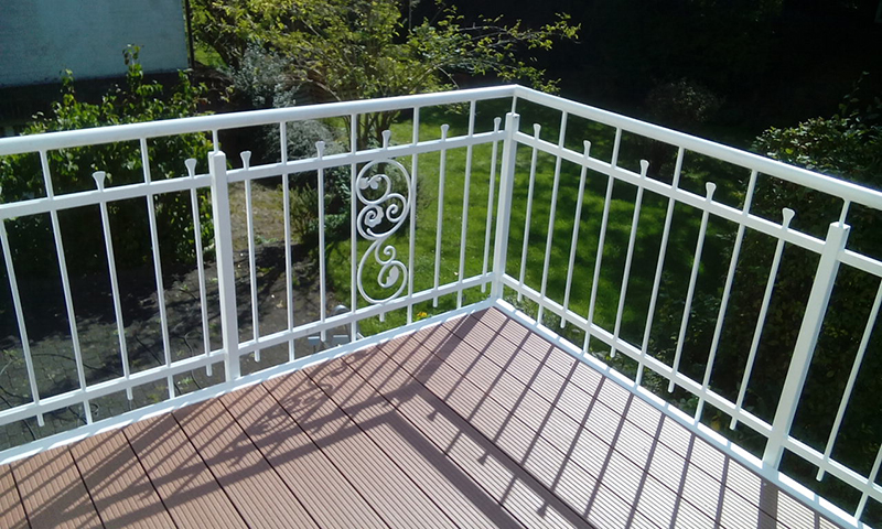 Weißes Balkongeländer mit Ornamentelement auf einer Terrasse